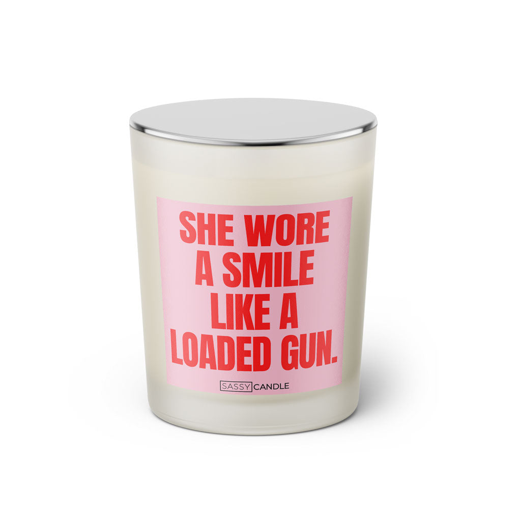 Duftkerze mit witzigen Spruch: She wore a smile like a loaded gun. Farbe rosa und pink von Sassy Candle.