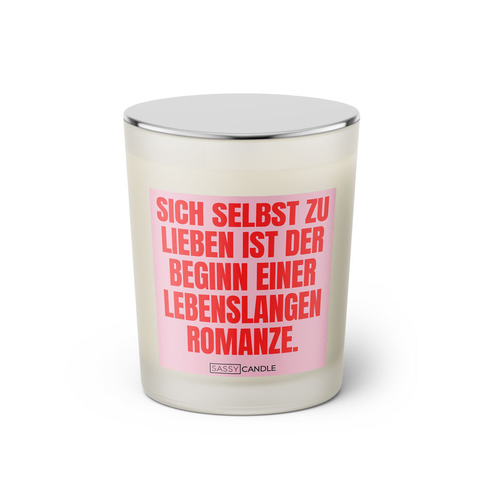 Duftkerze mit witzigen Spruch: Sich selbst zu lieben ist der Beginn einer lebenslangen Romanze. Farbe rosa und pink von Sassy Candle.