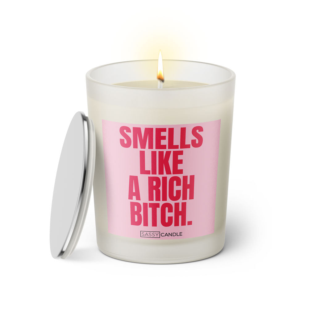 Duftkerze mit witzigem Spruch: Smells like a rich bitch. Farbe rosa und pinke Schrift. Kerzenglas mit silbernem Deckel von SassyCandle.