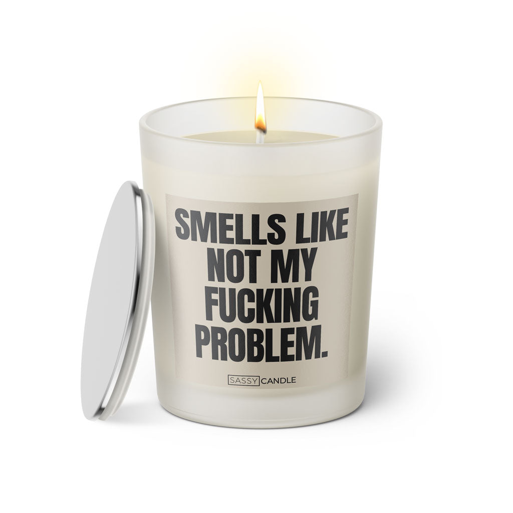 Duftkerze mit witzigem Spruch: Smells like not my fucking Problem. Farbe beige und schwarze Schrift. Kerzenglas mit silbernem Deckel von SassyCandle.