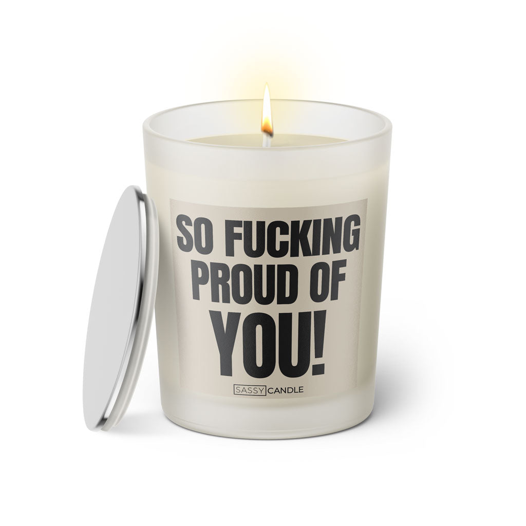 Duftkerze mit witzigen Spruch: So fucking proud of you! Farbe beige und schwarz mit silbernen Deckel von Sassy Candle.