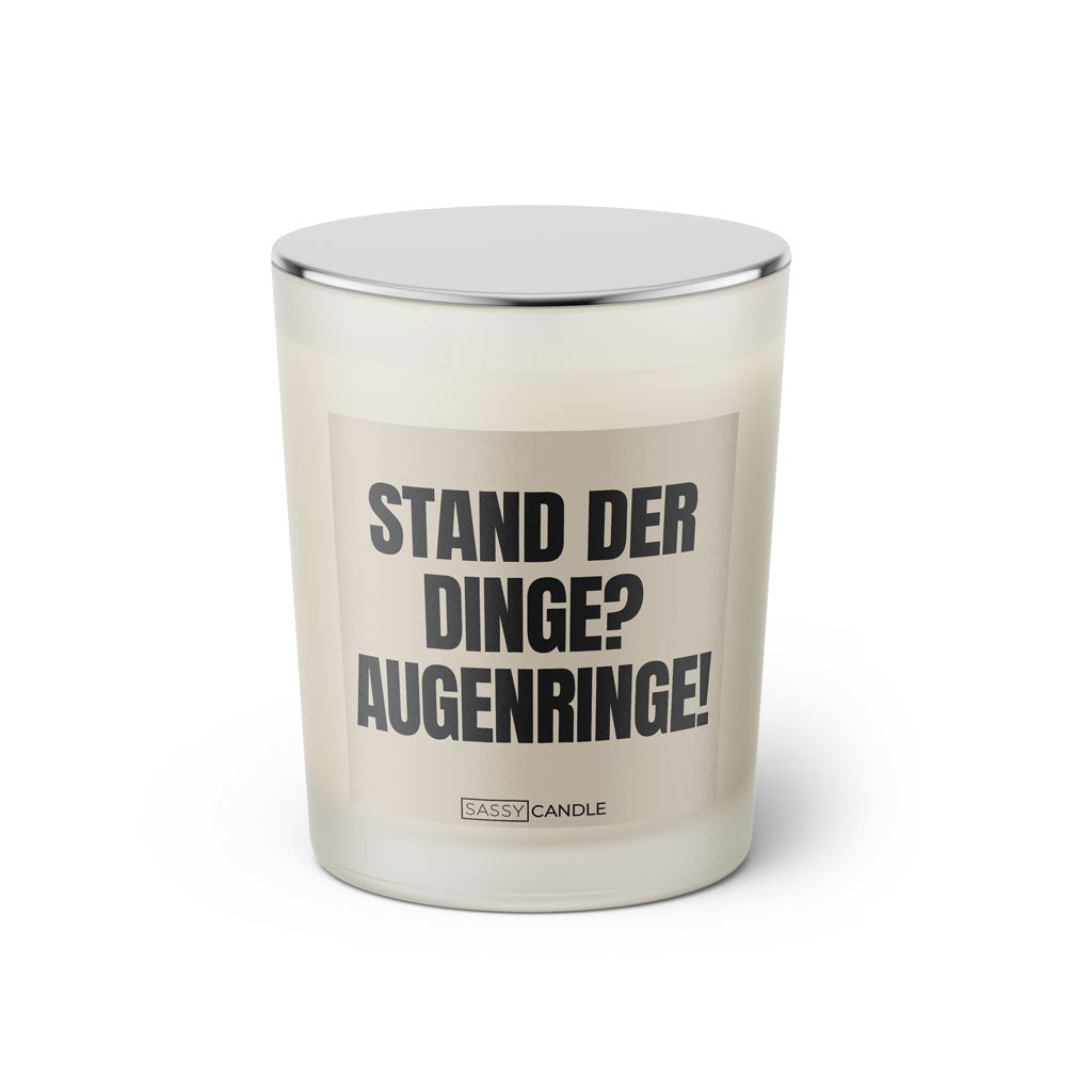 Duftkerze mit Spruch: Stand der Dinge? Augenringe! Farbe beige und schwarz von Sassy Candle.