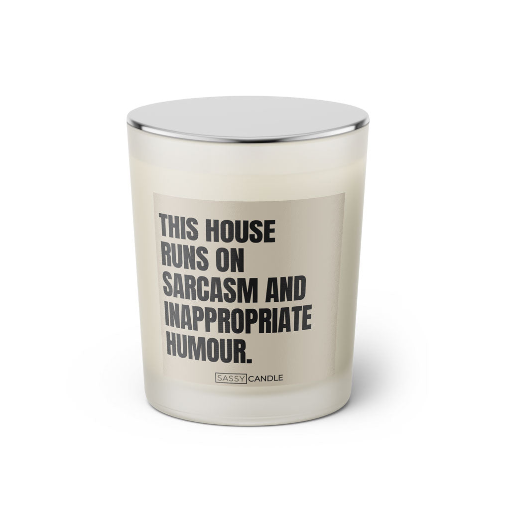 Duftkerze mit witzigen Spruch: This house runs on sarcasm and inappropriate humour. Farbe beige und schwarz. Kerze von Sassy Candle.