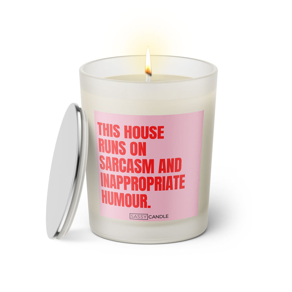 Duftkerze mit witzigen Spruch: This house runs on sarcasm and inappropriate humour. Farbe rosa und pink. Kerze von Sassy Candle.