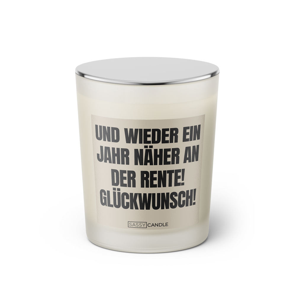 Duftkerze mit witzigen Spruch in der Farbe beige und schwarz von Sassy Candle. Spruch auf Etikett:Und wieder ein Jahr näher an der Rente! Glückwunsch!