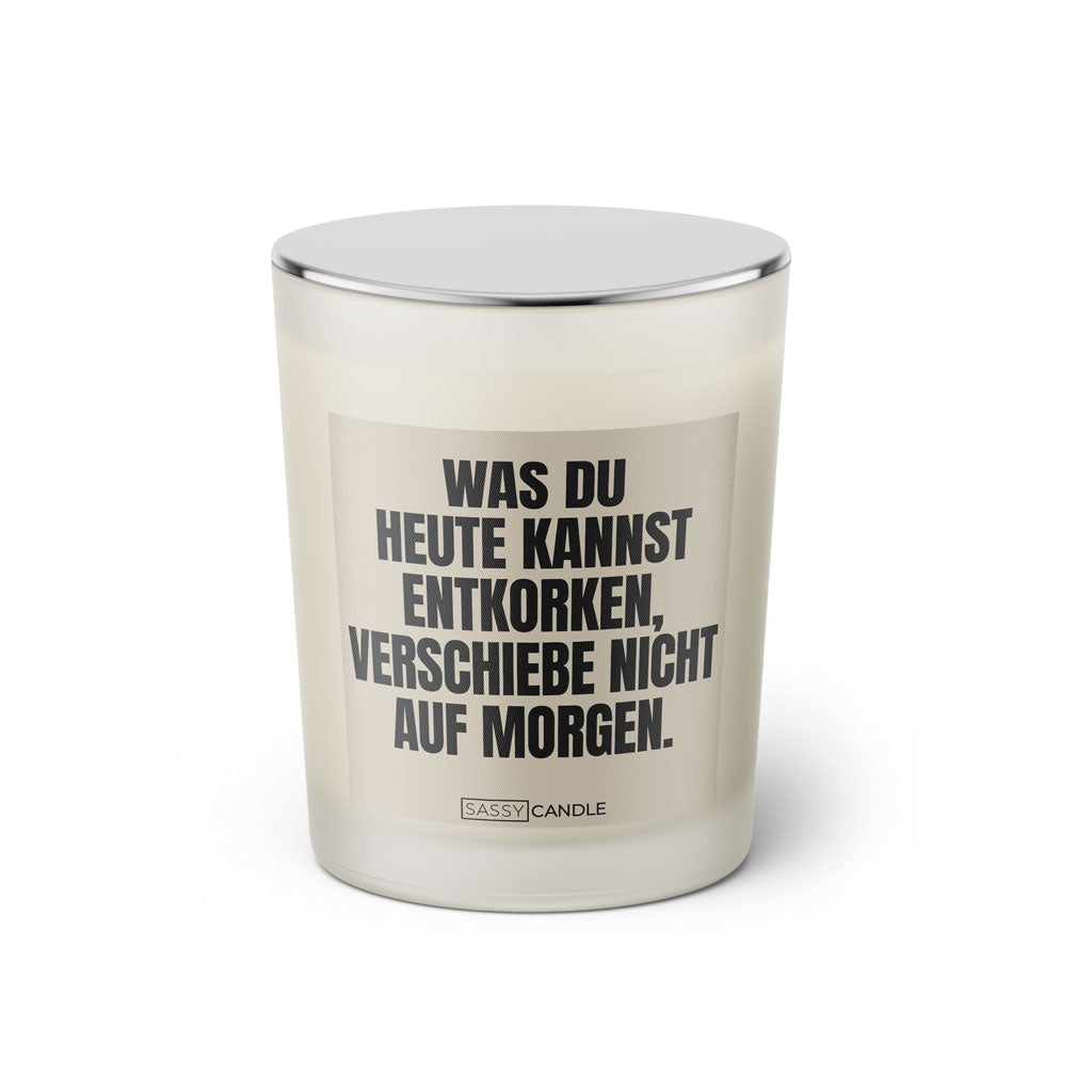 Duftkerze mit witzigem Spruch: Was du heute kannst entkorken, verschiebe nicht auf morgen. Farbe beige und schwarze Schrift. Kerzenglas mit silbernem geschlossenem Deckel von SassyCandle.