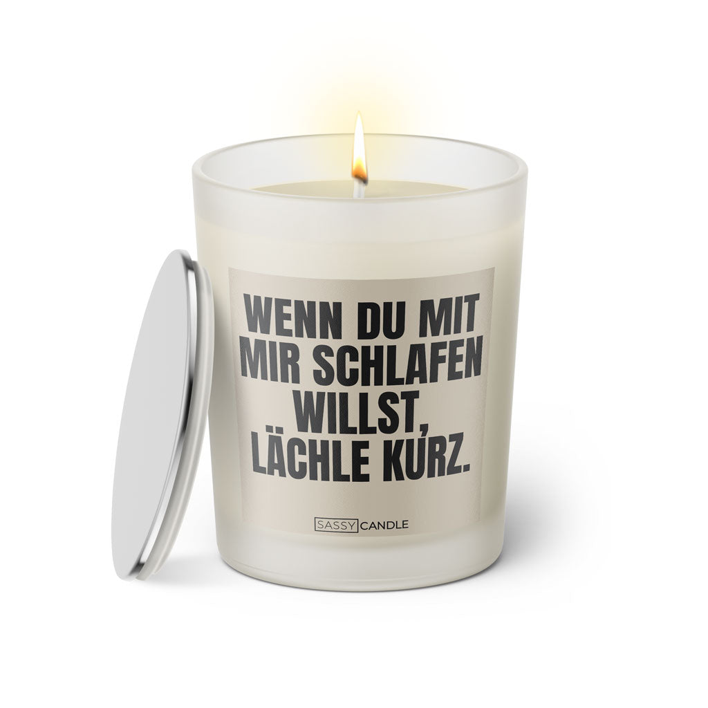 Duftkerze mit witzigem Spruch: Wenn du mit mir schlafen willst, lächle kurz. Farbe beige und schwarze Schrift. Kerzenglas mit silbernem Deckel von SassyCandle.