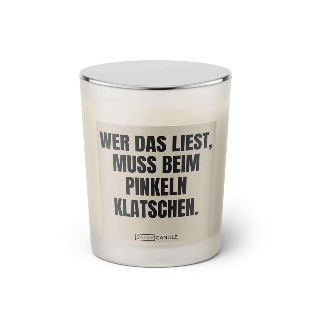 Duftkerze mit witzigem Spruch: Wer das liest muss beim pinkeln klatschen. Farbe beige und schwarze Schrift. Kerzenglas mit silbernem geschlossenem Deckel von SassyCandle.