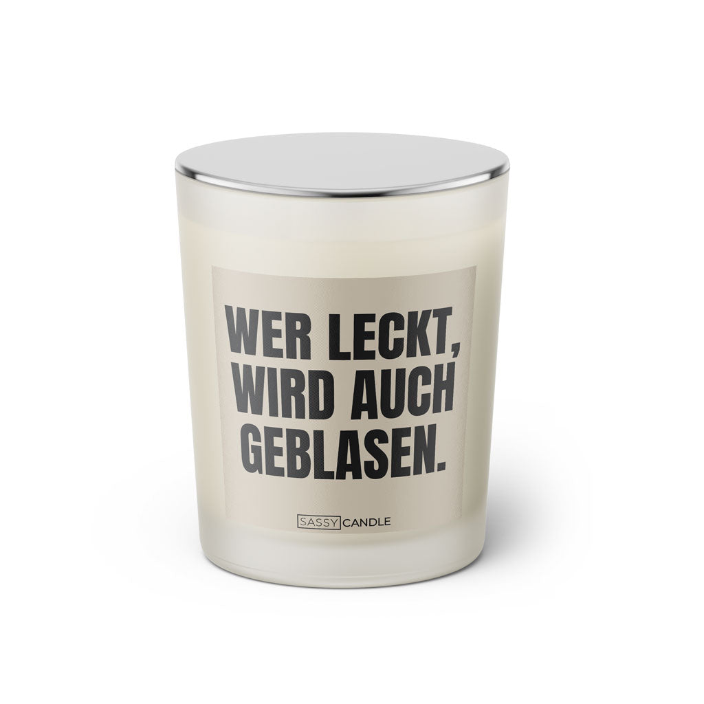 Duftkerze mit witzigem Spruch: Wer leckt wird auch geblasen. Farbe beige und schwarze Schrift. Kerzenglas mit silbernem geschlossenem Deckel von SassyCandle.