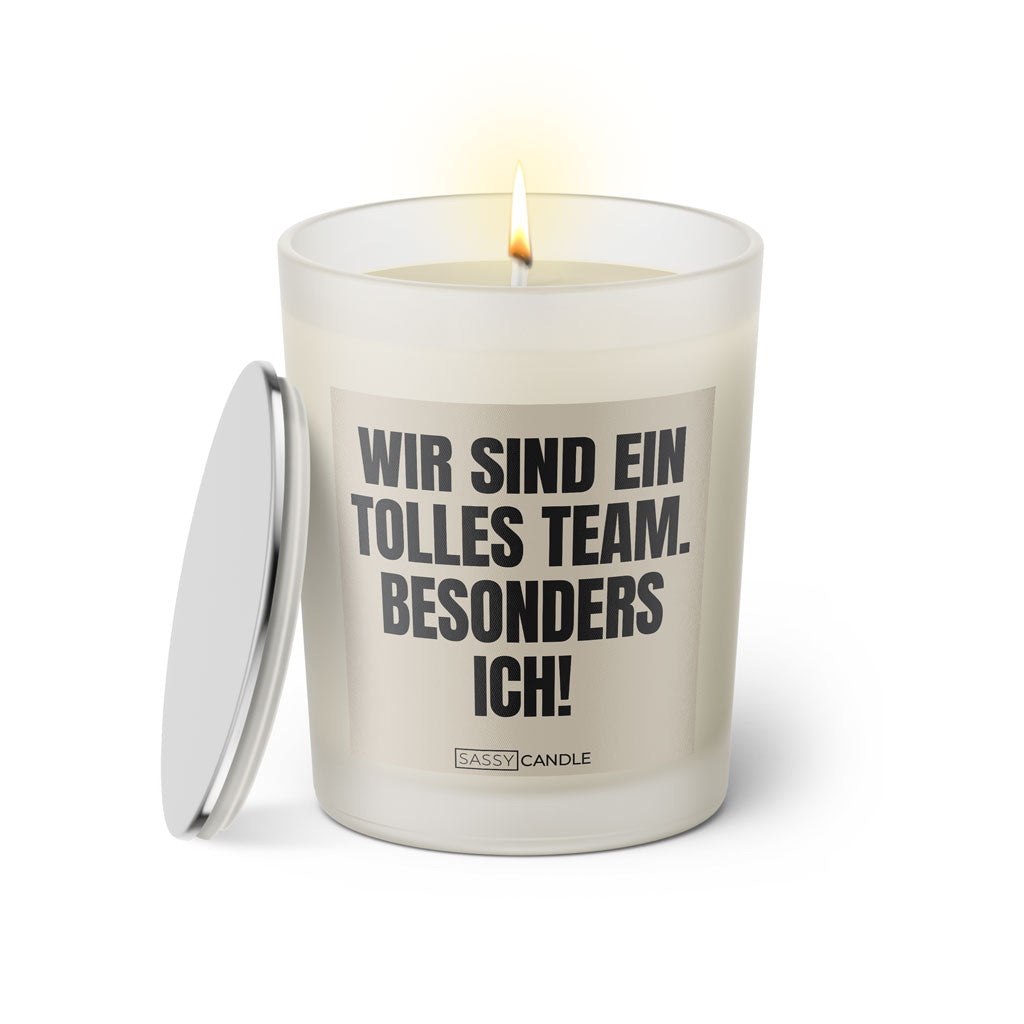 Duftkerze mit witzigem Spruch: Wir sind ein tolles Team. Besonders ich! Farbe beige und schwarze Schrift. Kerzenglas mit silbernem Deckel von SassyCandle.
