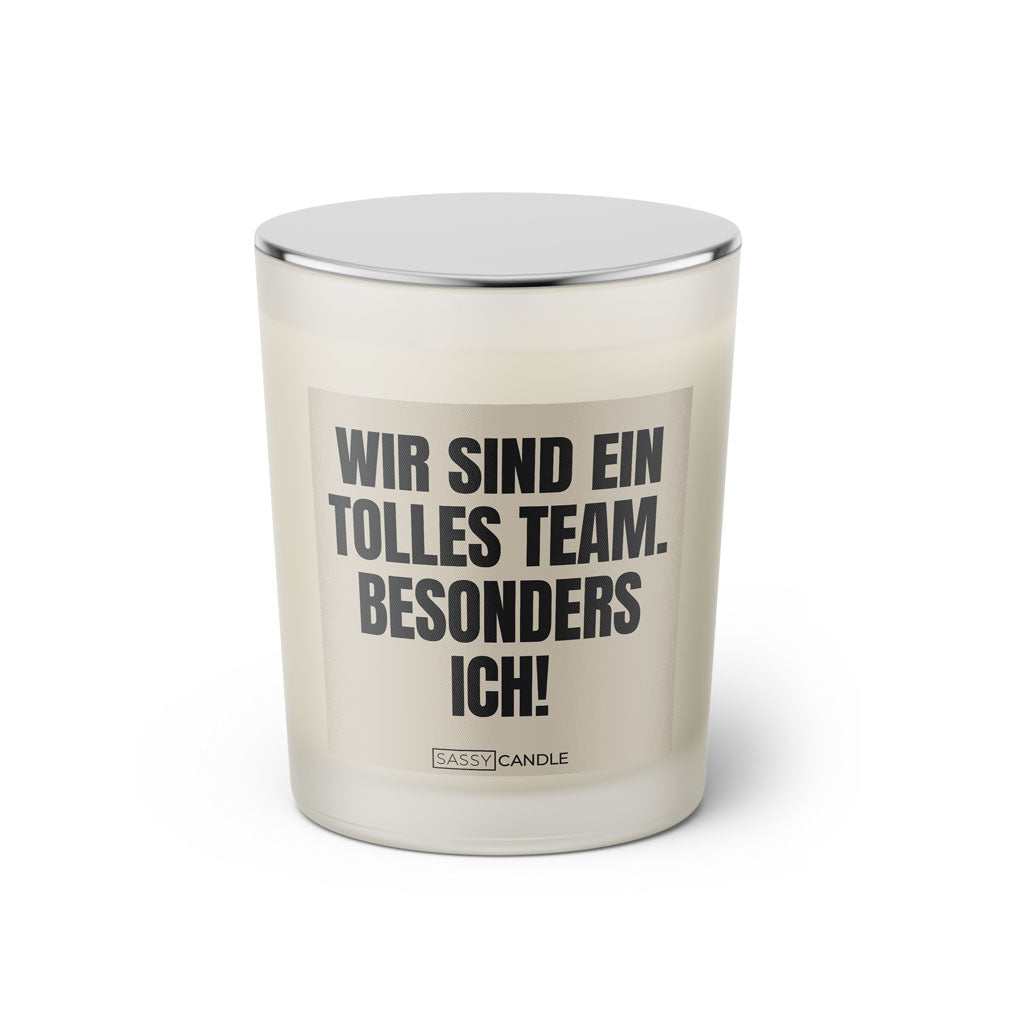 Duftkerze mit witzigem Spruch: Wir sind ein tolles Team. Besonders ich! Farbe beige und schwarze Schrift. Kerzenglas mit silbernem geschlossenem Deckel von SassyCandle.