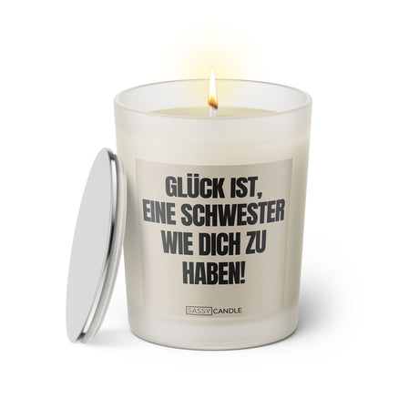 Duftkerze mit witzigem Spruch: Glück ist, eine Schwester wie dich zu haben! Farbe beige und schwarze Schrift. Kerzenglas mit silbernem Deckel von SassyCandle.