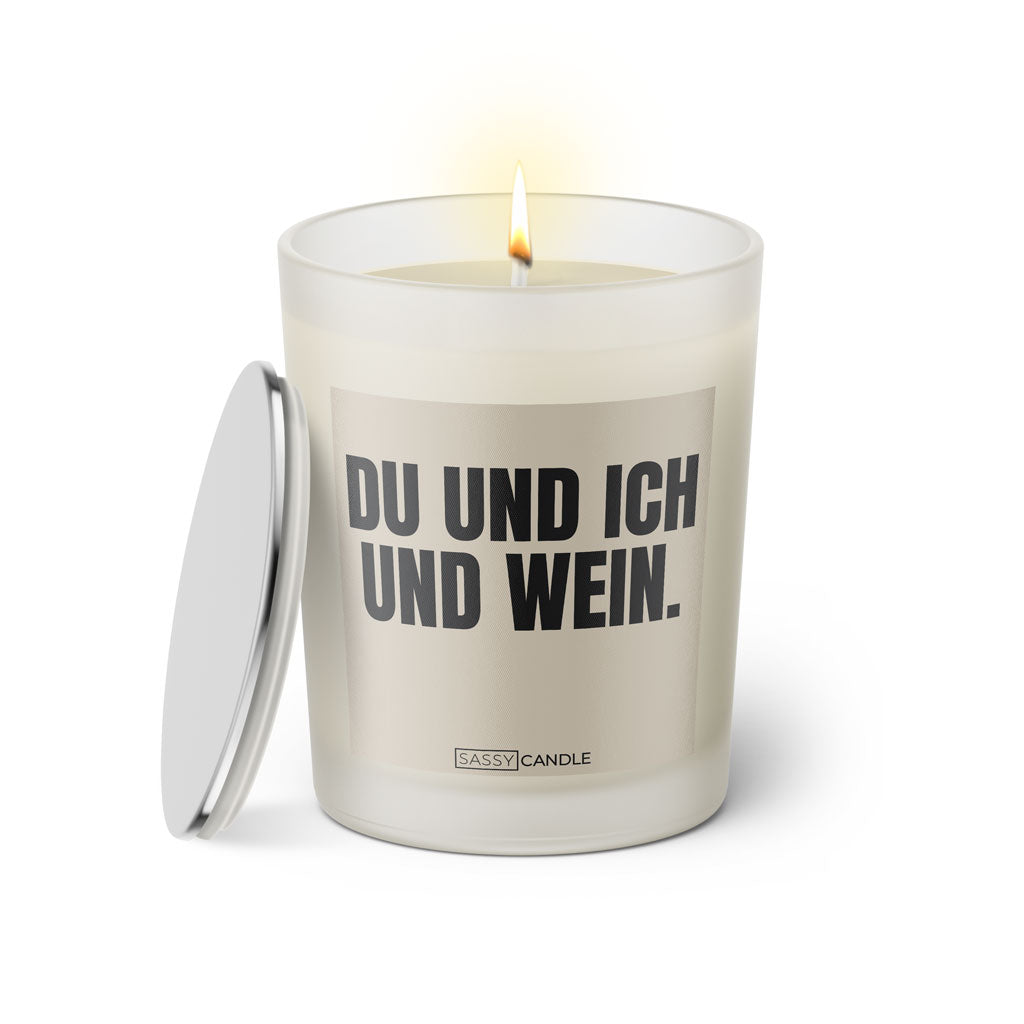 Duftkerze mit witzigem Spruch: Du und Ich und Wein. Farbe beige und schwarze Schrift. Kerzenglas mit silbernem Deckel von SassyCandle.