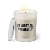 Duftkerze mit witzigem Spruch: Du wirst alt Schwester. Farbe beige und schwarze Schrift. Kerzenglas mit silbernem Deckel von SassyCandle.