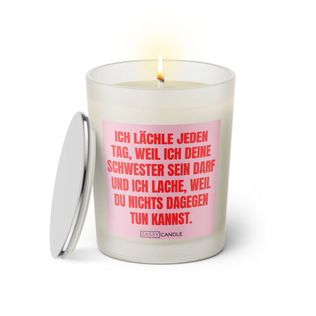 Duftkerze mit witzigen Spruch: Ich lächle jeden Tag, weil ich deine Schwester sein darf und ich lache, weil du nichts dagegen tun kannst. Kerzenglas mit silbernen Deckel. Farbe rosa und pink von Sassy Candle.