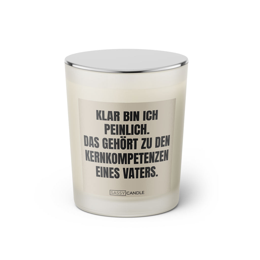 Duftkerze mit witzigem Spruch: Klar bin ich peinlich. Das gehört zu den Kernkompetenzen eines Vaters. Farbe beige und schwarze Schrift. Kerzenglas mit silbernem geschlossenem Deckel von SassyCandle.