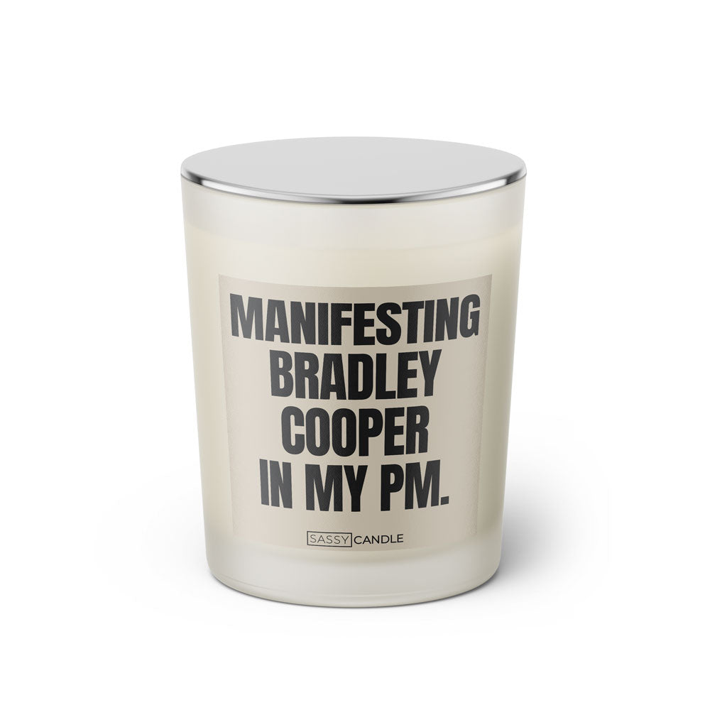 Duftkerze mit witzigen Spruch: Manifesting Bradley Cooper in my PM. Farbe beige und schwarz von Sassy Candle.