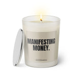 Duftkerze mit witzigem Spruch: Manifestant Money. Farbe beige und schwarze Schrift. Kerzenglas mit silbernem Deckel von SassyCandle.