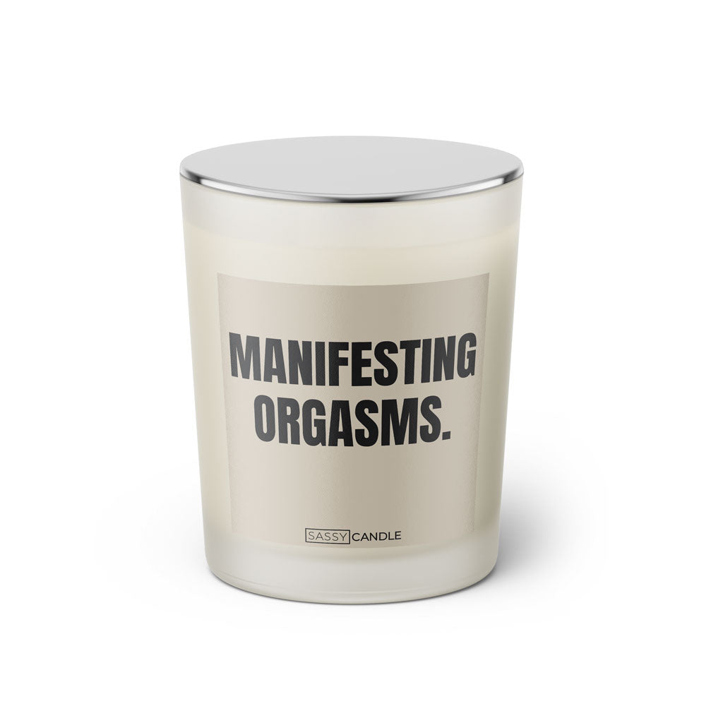 Duftkerze mit witzigem Spruch: Manifesting Orgasms. Farbe beige und schwarze Schrift. Kerzenglas mit silbernem geschlossenem Deckel von SassyCandle.