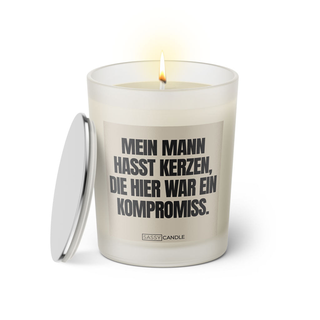 Duftkerze mit witzigem Spruch: Mein Mann hasst Kerzen die hier war ein Kompromiss. Farbe beige und schwarz mit silbernem Deckel von Sassy Candle.