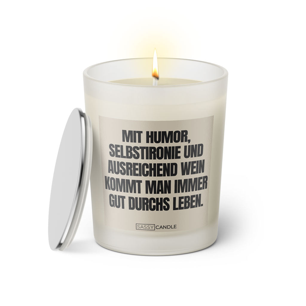 Duftkerze mit witzigem Spruch: Mit Humor, Selbstironie und ausreichend Wein kommt man immer gut durchs Leben. Farbe beige und schwarze Schrift. Kerzenglas mit silbernem Deckel von SassyCandle.