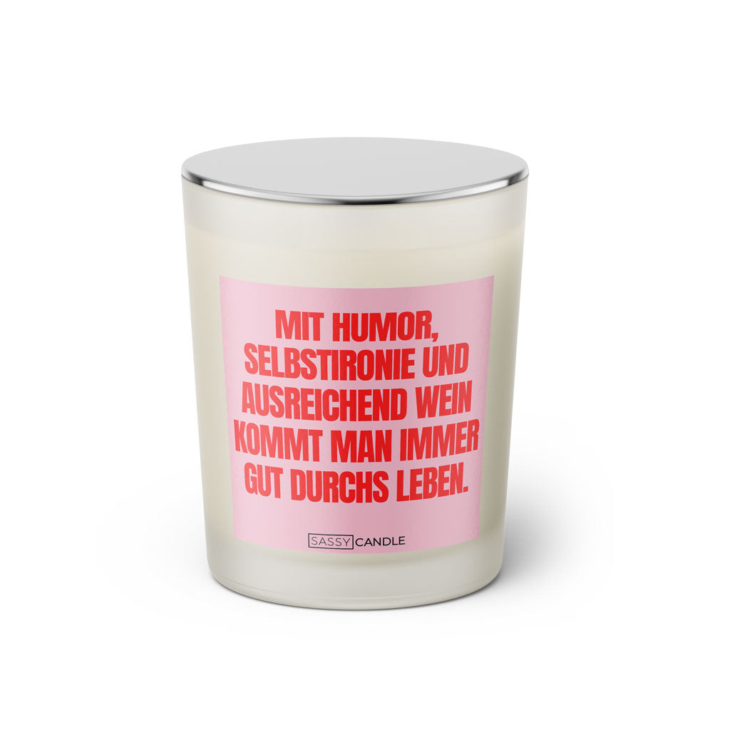 Duftkerze mit witzigem Spruch: Mit Humor, Selbstironie und ausreichend Wein kommt man immer gut durchs Leben. Farbe rosa und pinke Schrift. Kerzenglas mit silbernem geschlossenem Deckel von SassyCandle.