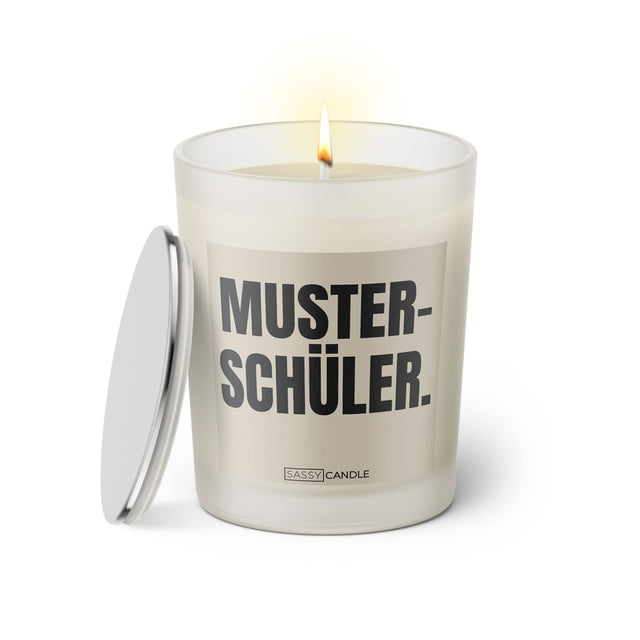 Duftkerze mit witzigem Spruch: Musterschüler. Farbe beige und schwarze Schrift. Kerzenglas mit silbernem geschlossenem Deckel von SassyCandle.