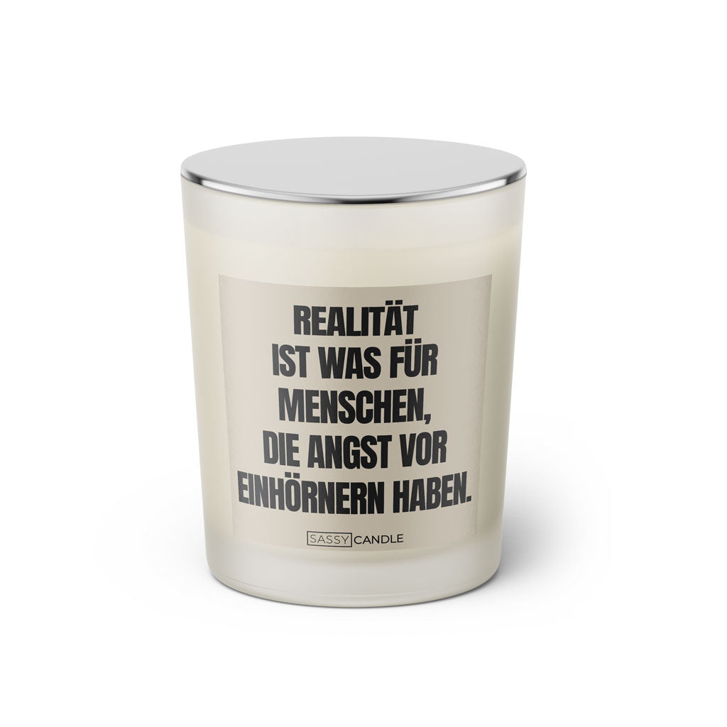 Duftkerze mit witzigen Spruch: Realität ist was für Menschen, die Angst vor Einhörnern haben Farbe beige und schwarz von Sassy Candle.