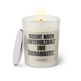 Duftkerze mit witzigem Spruch: Riecht nach unterbezahlt und überarbeitet. Farbe beige und schwarze Schrift. Kerzenglas mit silbernem Deckel von SassyCandle.