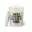 Duftkerze mit witzigen Spruch: She's a little sass and a lot of badass. Farbe beige und schwarz mit silbernen Deckel von Sassy Candle.