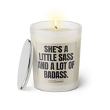 Duftkerze mit witzigen Spruch: She's a little sass and a lot of badass. Farbe beige und schwarz mit silbernen Deckel von Sassy Candle.