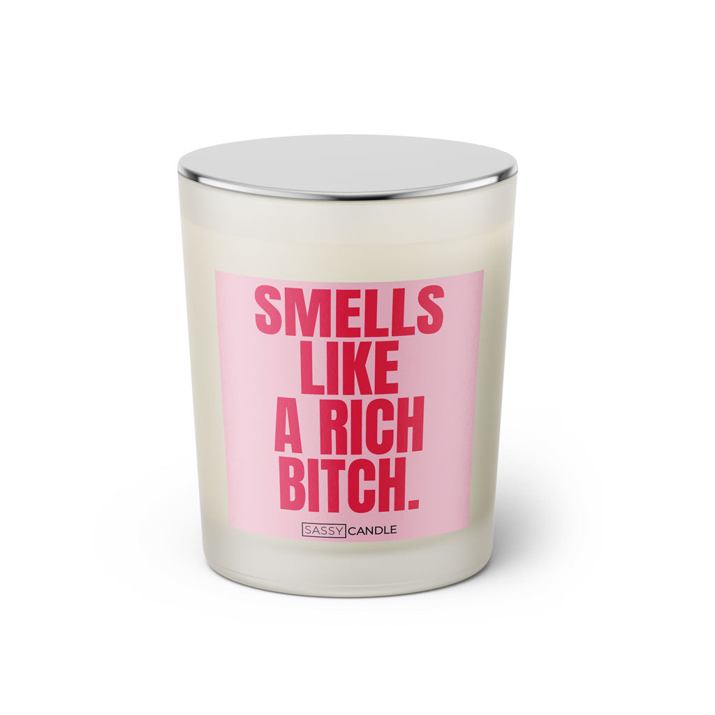 Duftkerze mit witzigem Spruch: Smells like a rich bitch. Farbe rosa und pinke Schrift. Kerzenglas mit silbernem geschlossenem  Deckel von SassyCandle.