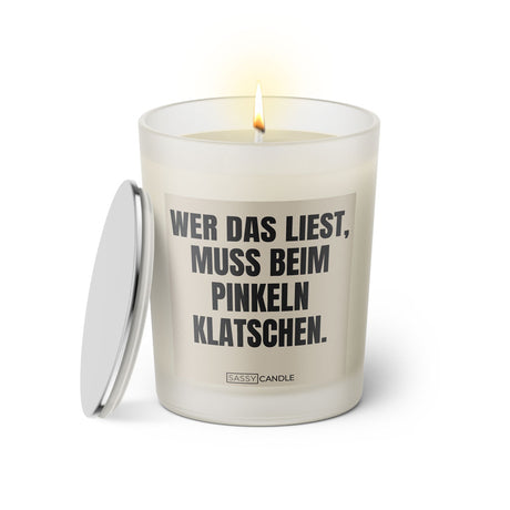 Duftkerze mit witzigem Spruch: Wer das liest muss beim pinkeln klatschen. Farbe beige und schwarze Schrift. Kerzenglas mit silbernem Deckel von SassyCandle.