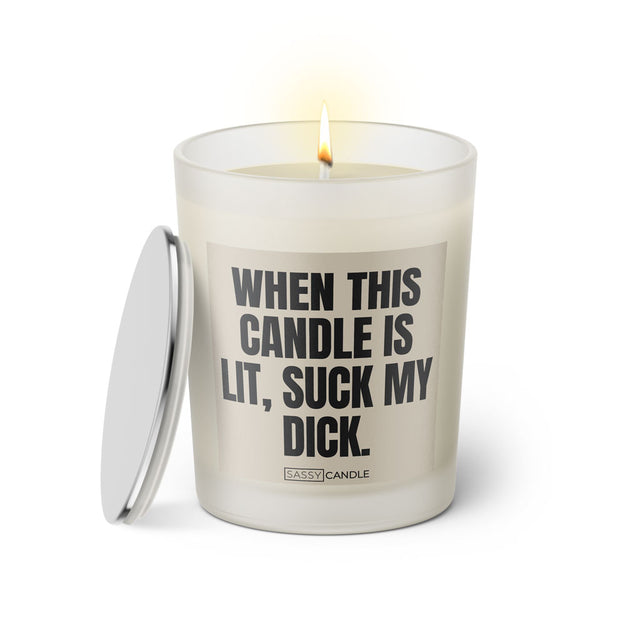 Duftkerze mit witzigem Spruch: When this candle is lit, suck my dick. Farbe beige und schwarze Schrift. Kerzenglas mit silbernem Deckel von SassyCandle.